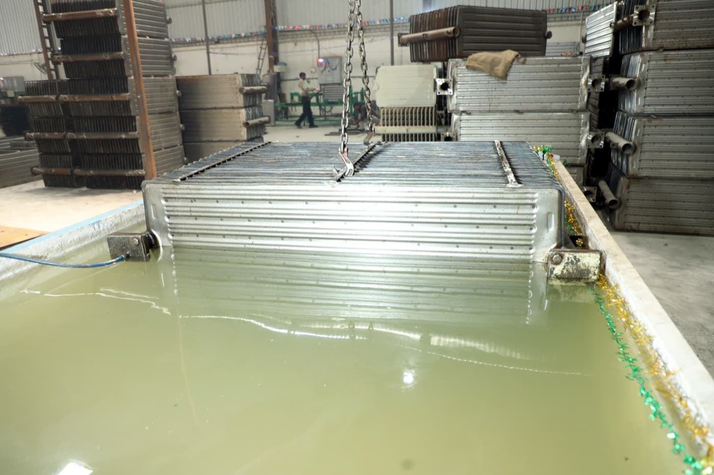 Welder joining radiator panels onto a header assembly